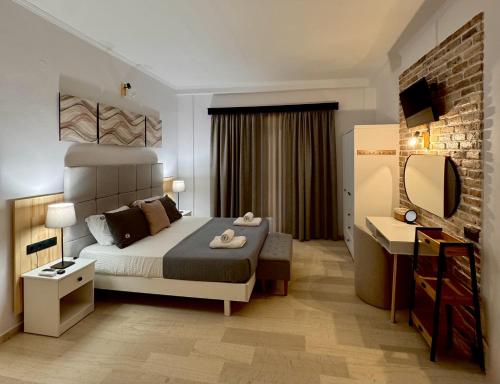 a hotel room with a bed and a mirror at Summerscape Studios and Apartments in Corfu