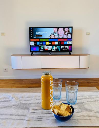 a can of soda and chips on a table with a television at Blue Harmony in Massy