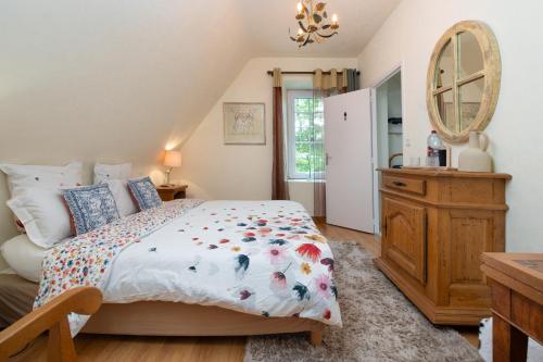 a bedroom with a bed and a dresser and a mirror at Le Moulin De Lesnevé in Saint-Avé