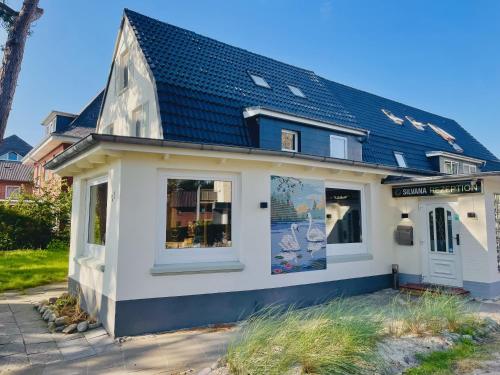 a small white house with a black roof at Hotel Silvana in Böhl