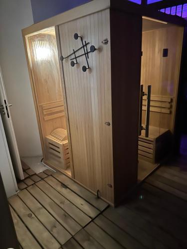a wooden closet with a door in a room at Le Durivum in Montaigu-Vendée