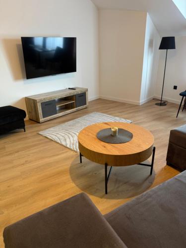 a living room with a coffee table and a flat screen tv at Apartament Umami in Pniewy