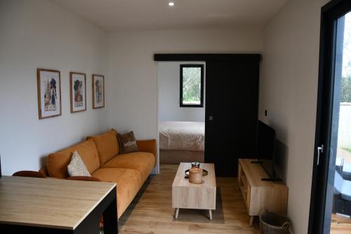 a living room with a couch and a table at Lilikaz in Saint-Laurent-de-la-Prée