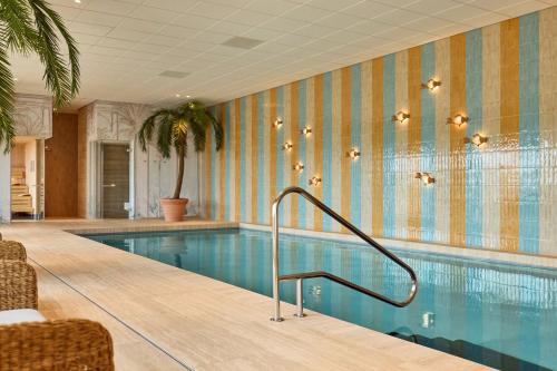 a swimming pool in a hotel room with a swimming pool at Van der Valk Hotel Groningen-Hoogkerk in Groningen