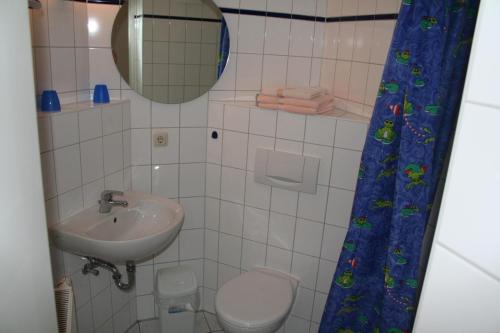 a bathroom with a sink and a toilet and a mirror at Gaestehaus-W-13 in Prerow