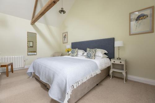 a bedroom with a large bed with a blue headboard at The Hat Shop in Hexham