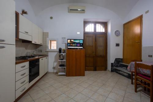 a kitchen with white cabinets and a sink and a stove at Dimora Dina Guglionesi in Guglionesi