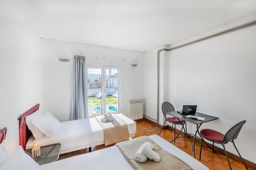 a bedroom with a bed and a table and chairs at HI Ofir – Pousada de Juventude in Esposende