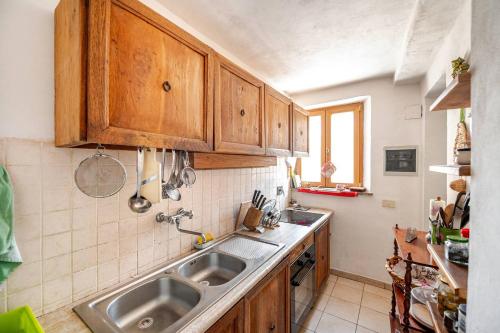 a kitchen with wooden cabinets and a sink at Collazzone - "Il Tramonto" casale con piscina in Collazzone