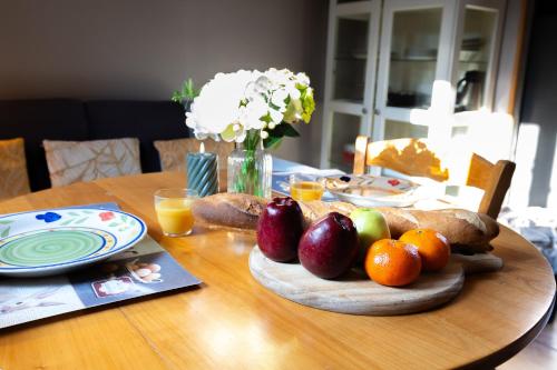 a wooden table with a plate of fruit on it at Les Colombes in Saint-Tricat