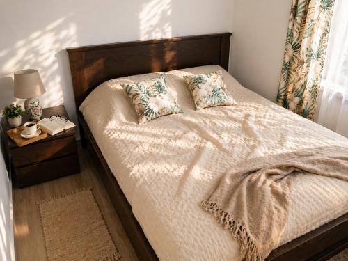 a bedroom with a bed with a wooden headboard and pillows at Petrović Garden in Inđija