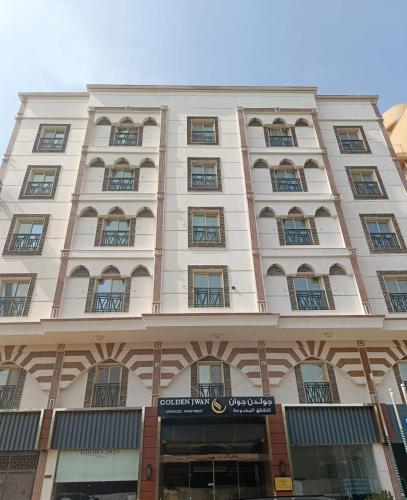 a large white building with a sign in front of it at شقق جوان الذهبية الاولى للشقق المخدومة اقتصادية in Jeddah