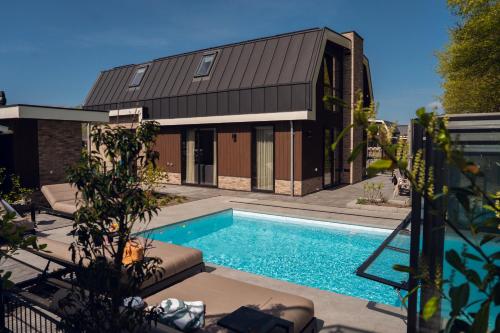 a house with a swimming pool next to a building at Vakantierijk Waarland in Waarland