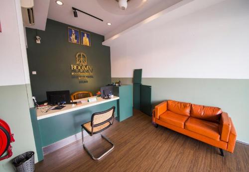 an office with an orange couch and a desk at Room V Jalan Jenang by SECOMS in Batu Pahat