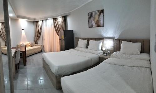 a hotel room with two beds and a desk at Scandic resort chalet in Hurghada