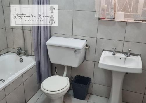 a bathroom with a toilet and a sink at Steytlerville Karoo Backpackers in Steytlerville
