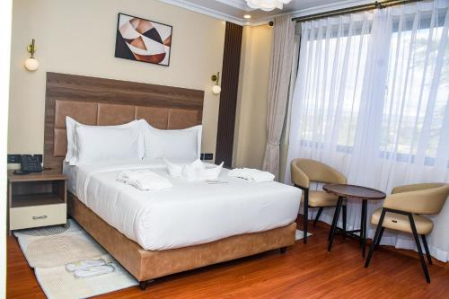 a hotel room with a bed and a table and chairs at Sebai Luxury Suites in Naivasha