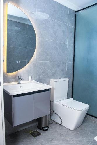 a bathroom with a toilet and a sink and a mirror at Sebai Luxury Suites in Naivasha