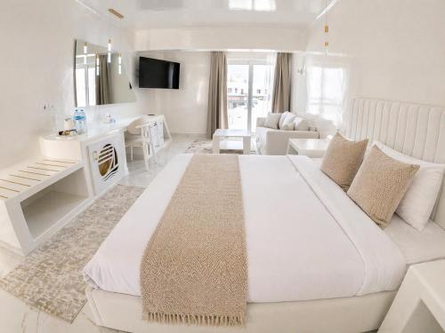 a white bedroom with a large bed and a living room at Verginia Sharm Resort & Aqua Park in Sharm El Sheikh
