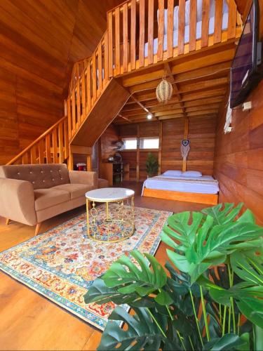 a living room with a couch and a table at Cabin Dieng Db in Diyeng