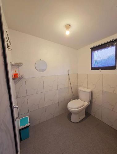 a bathroom with a toilet and a window at Cabin Dieng Db in Diyeng