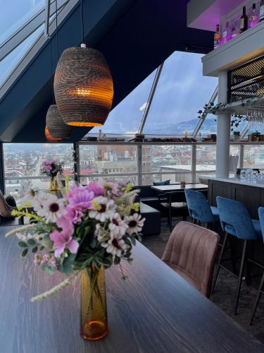 a vase of flowers on a table in a restaurant at Aksjemøllen - by Classic Norway Hotels in Lillehammer