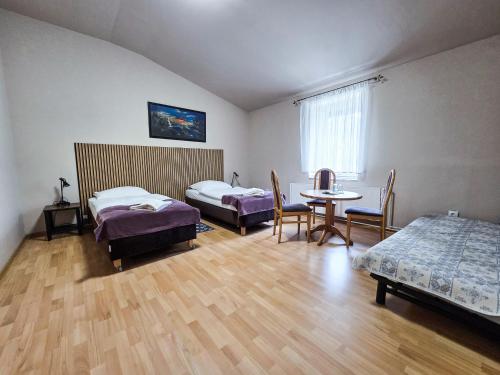 a room with two beds and a table and chairs at Hotel Komfort Inn - Dwór Hubertus in Piekary Śląskie