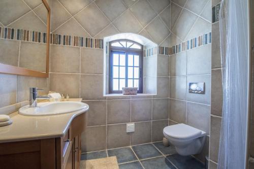 a bathroom with a sink and a toilet and a window at Villa Angel by Algarve Holidays in Loulé