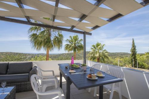 a patio with a blue table and white chairs at Villa Angel by Algarve Holidays in Loulé