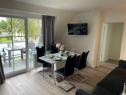 a living room with a table and chairs and a dining room at Seaside-Amrum-13 in Norddorf