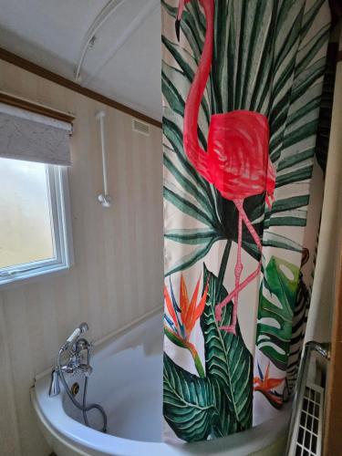 a bathroom with a pink flamingo on the shower curtain at Ruth's Repose Shropshire Country Retreat with private hot tub & Stunning Views in Shrewsbury