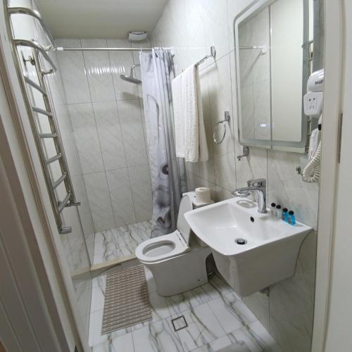 a bathroom with a toilet and a sink and a shower at MIMFRI guest house,hotel in Tashkent