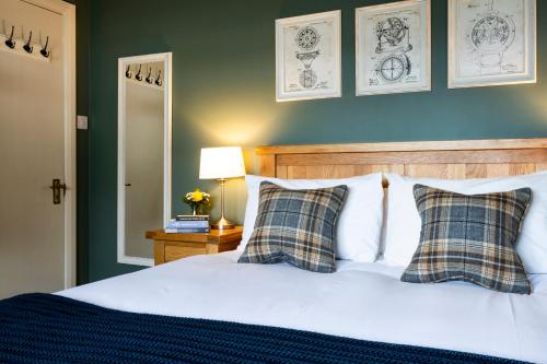a bedroom with a white bed with two checked pillows at Margaret's Cottage B&B in Ardglass