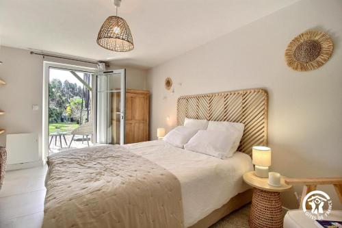 a bedroom with a large bed and a balcony at Le clos du figuier in Arzon