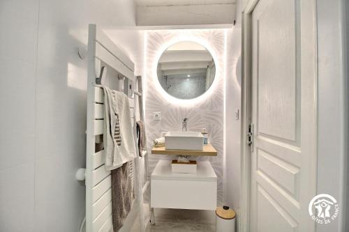 a bathroom with a sink and a mirror at Le clos du figuier in Arzon