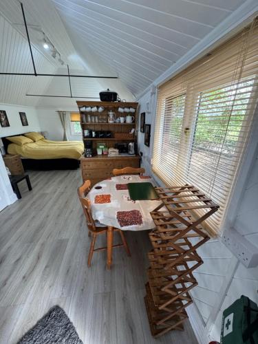 a room with a table and chairs in a room at Woodland Chalet at Otters Green in Botley