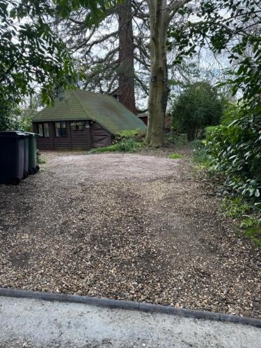 a gravel driveway in front of a house at Woodland Chalet at Otters Green in Botley