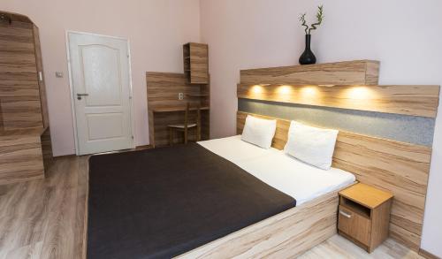 a bedroom with a large bed with a wooden headboard at Centrooms House in Budapest