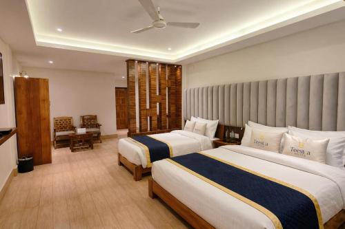 a hotel room with two beds and a window at Teesta Hotels, Kalimpong in Kalimpong
