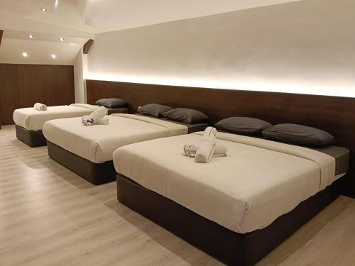 a row of three beds in a room at D GAYA HOTEL Cameron Highlands in Tanah Rata