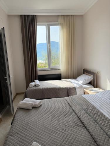a hotel room with two beds and a window at Guest House MD 2 in Tatʼev