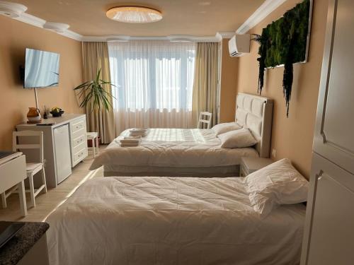 a hotel room with two beds and a desk at Emanuela Home in Piatra Neamţ