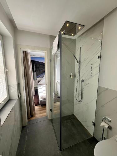 a bathroom with a shower with a glass door at Strandhotel Sylt Wenningstedt in Wenningstedt