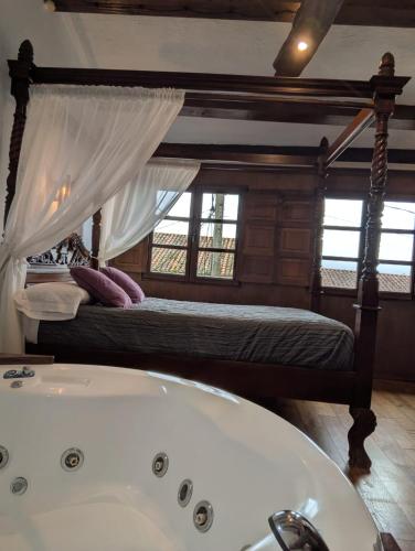 a bathroom with a bath tub and a bed at Las Casas de Isu in Villaviciosa