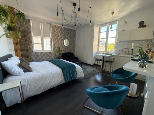a bedroom with a bed and a kitchen with a table at La Loge 45 in Rodez