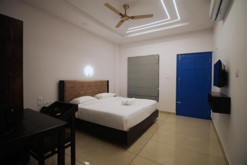a bedroom with a bed and a blue door at Travlounge Adimali in Chillithodu