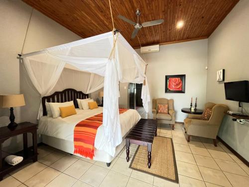 a bedroom with a bed with a canopy at Abangane Guest Lodge in Hazyview