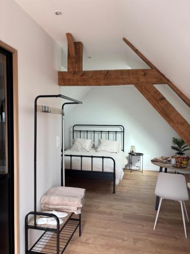 a bedroom with a bed and a wooden floor at La Bercerie in Peuplingues
