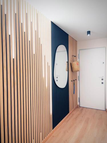 a hallway with a blue wall and a mirror at Sunny Waves Apartment in Cullera