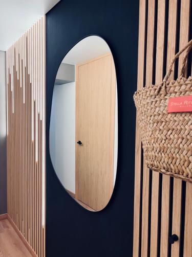 a round mirror on a blue wall with a door at Sunny Waves Apartment in Cullera